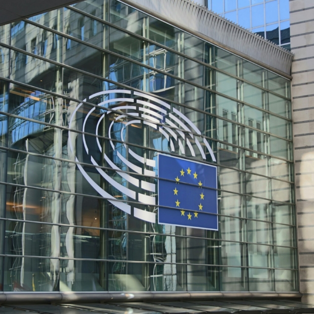 A wall of glass windows with the EU logo
